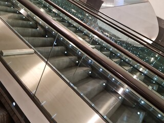 Obraz premium moving escalator in airport. Macro view of escalator in a subway station. People like travel with comfort. Beautiful interior with modern technology. Industrial background for creative design layout.