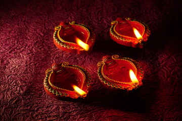Oil lamps (Clay diya) lit on colorful rangoli during diwali celebration.Greeting Card Design Indian Hindu Light Festival called Diwali.