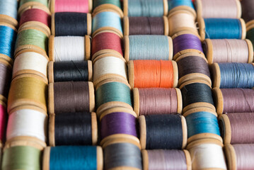 Multi-colored spools of thread close-up. Sewing threads multicolored background closeup