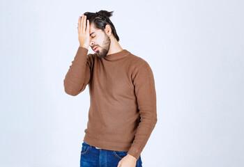Portrait of a young man with face palm gesture on white background © racool_studio