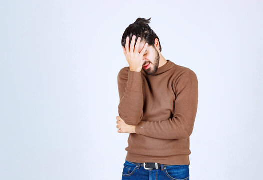 Portrait of a young man with face palm gesture on white background