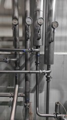 Industrial background of stainless steel pipes and gauges in production room of factory