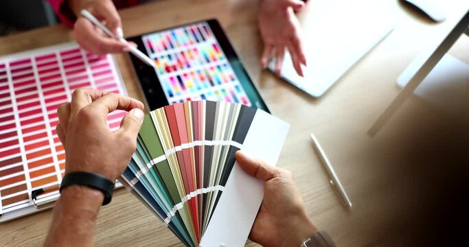 Designer helping client to choose color on sample for apartment renovation closeup 4k movie slow motion 