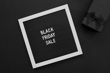 Black friday sale concept. Letter board, gift box on black background.Concept season sales time. Flat lay, top view, overhead