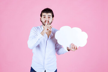 Person Holding a Cloud-shaped Object in Front of a Pink Background