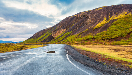 In The Middle Of A Wide Open Empty Road Surrounded By Mountains In Iceland