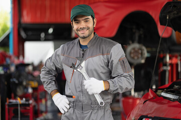 Portrait engine maintenance car mechanic with holding wrench self-confident with looking at camera....