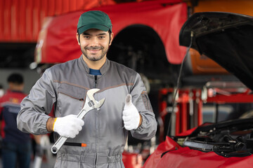Portrait engine maintenance car mechanic with holding wrench self-confident with looking at camera....