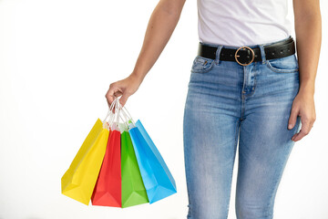 Unrecognizable young woman holding some colorful bags on a white background - shopping concept, sales, black friday, christmas