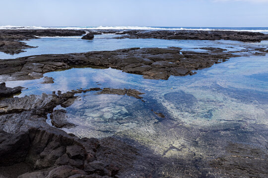 black lava rock shelf and ocean along coast at pu'uhonua o honaunau national historic park hawaii