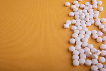Fototapeta na wymiar White Pills On Orange Surface