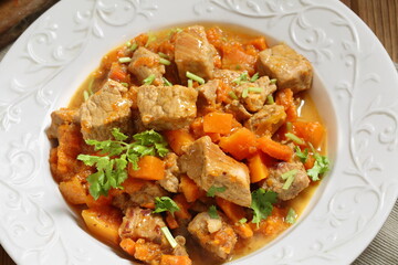 Roast pork with pumpkin on wooden background