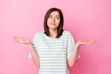 Photo portrait of gorgeous young lady look empty space shrug shoulders unsure wear trendy striped clothes isolated on pink color background