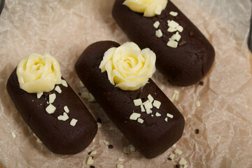 Cake potato. Decorated with butter cream. Against the background of black pine boards. Shot close-up.