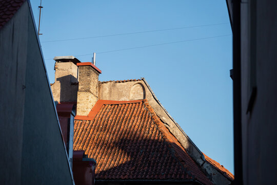 Old red tiled roof against the sky - view of the old city