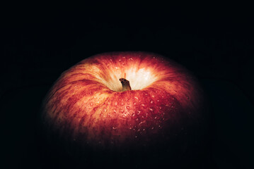fresh red apple On a black background with water droplets, lights are falling with space for text.