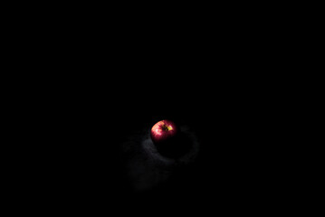 fresh red apple On a black background with water droplets, lights are falling with space for text.