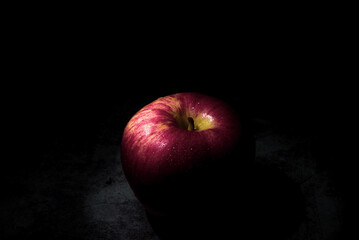 fresh red apple On a black background with water droplets, lights are falling with space for text.