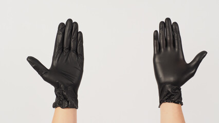 Two Hands is wear black latex gloves on white background.