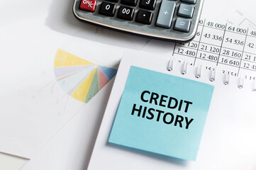 CREDIT HISTORY on a blue card in front of an office desk. Business concept