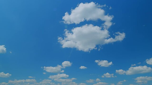 Summer blue sky and white clouds background. Layers of cloud space. Blue sky fluffy white clouds on summer season. Time lapse.