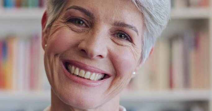 Face, smile and laugh with a happy senior woman laughing while standing in a library with books or shelves in the background. Portrait of Australian old lady looking confident with positive mindset