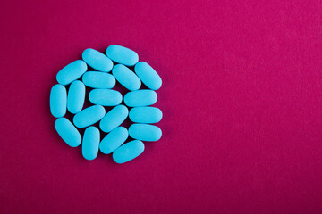 A pile of many blue with medicine lying in a heap on a rose background