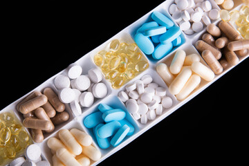 plastic container with pills on black background