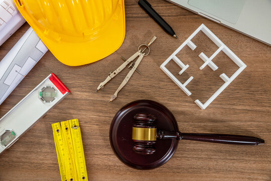 Construction and Labor law flat lay. Judge gavel and design tools on table