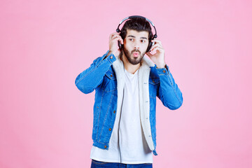 Man with headphones looks confused