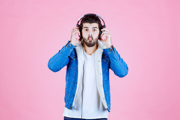 Man with headphones looks confused