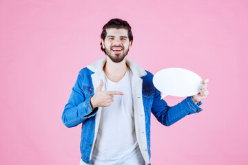 Man holding a think board and pointing at it