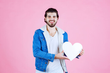 Man holding and presenting a blank heart figure with smiles