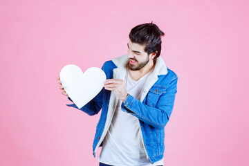 Man holding and presenting a blank heart figure with smiles