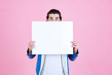Man hiding his face behind a square thinkboard