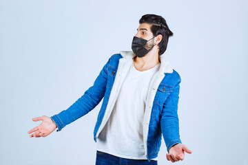 Man in black mask looks confused and trying to explain himself