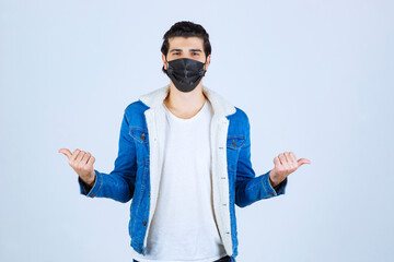 Man in black mask pointing to both sides