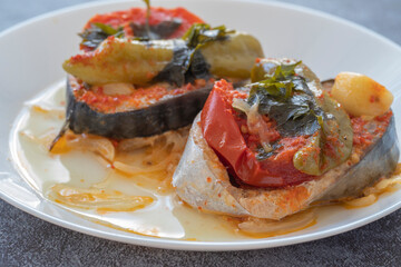 Delicious traditional Turkish fish dish, Palamut Pilaki. Presentation of a great fish dish on a white plate. top shot.