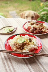 Vertical shot of a pet labrador looking at a table full of khmer food for breakfast 