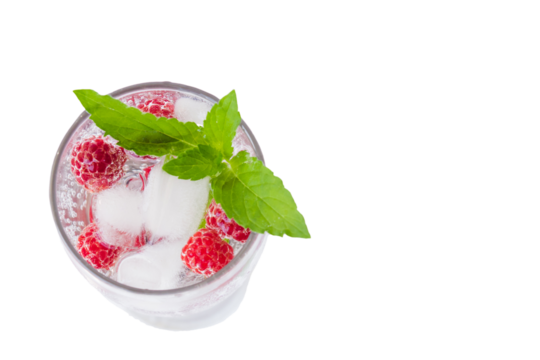 Carbonated drinks with fresh berries, mint and ice. Fresh cold sparkling bubble water with mint, raspberry, black and red currant in transparent glass with ice, top view macro. Food and drink concept
