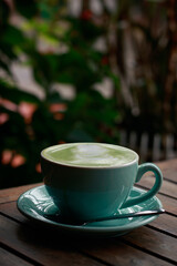 Vertical shot of a cup of matcha latte on a cold autumn day