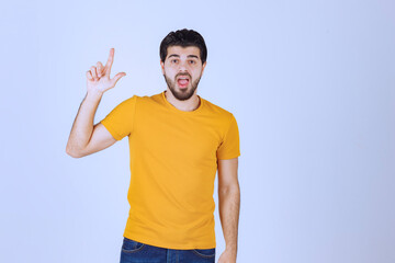 Man in yellow shirt looks doubtful and thinking