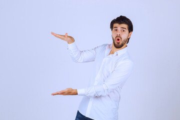 Man with beard showing estimated measures of an object