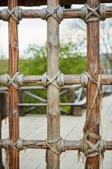 A fence made of thin wooden branches or logs tied with a rope. Medieval technology.