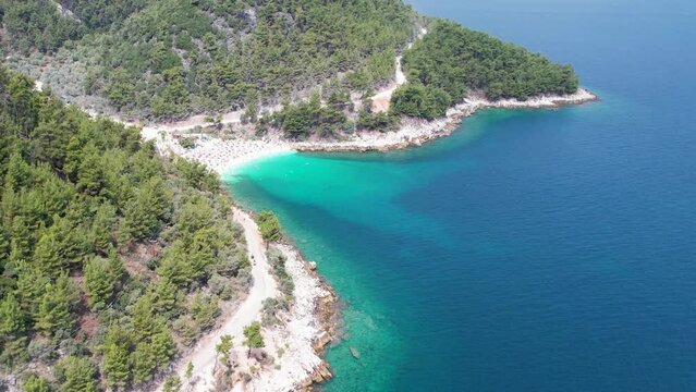 Aerial view of the beautiful Marble Beach on the Greek Island of Thassos in the Aegean Sea with turquoise waters. Drone footage of clear blue water with white sand on a summer day