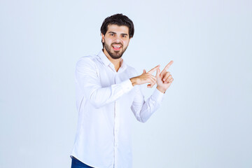 Man in white shirt pointing at something on the right