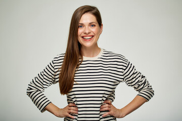 Obraz premium Smiling woman in striped shirt with hands on waist.