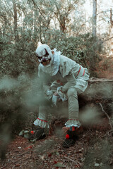 creepy evil clown sitting in the woods at dusk