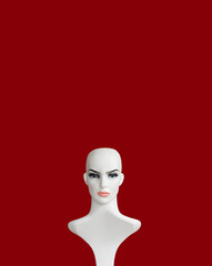 White plastic female mannequin  portrait on burgundy color background