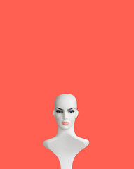 White plastic female mannequin doll portrait on orange color background